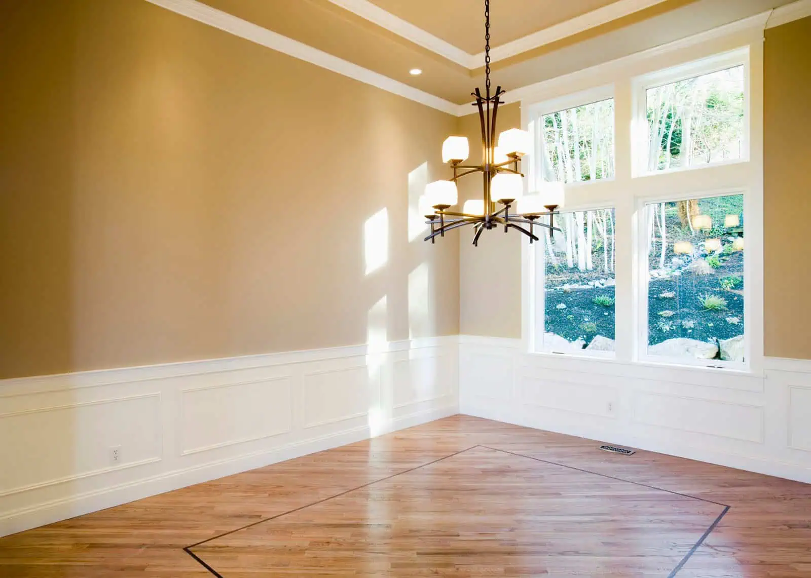 Bright dining room with large windows and modern chandelier lighting.