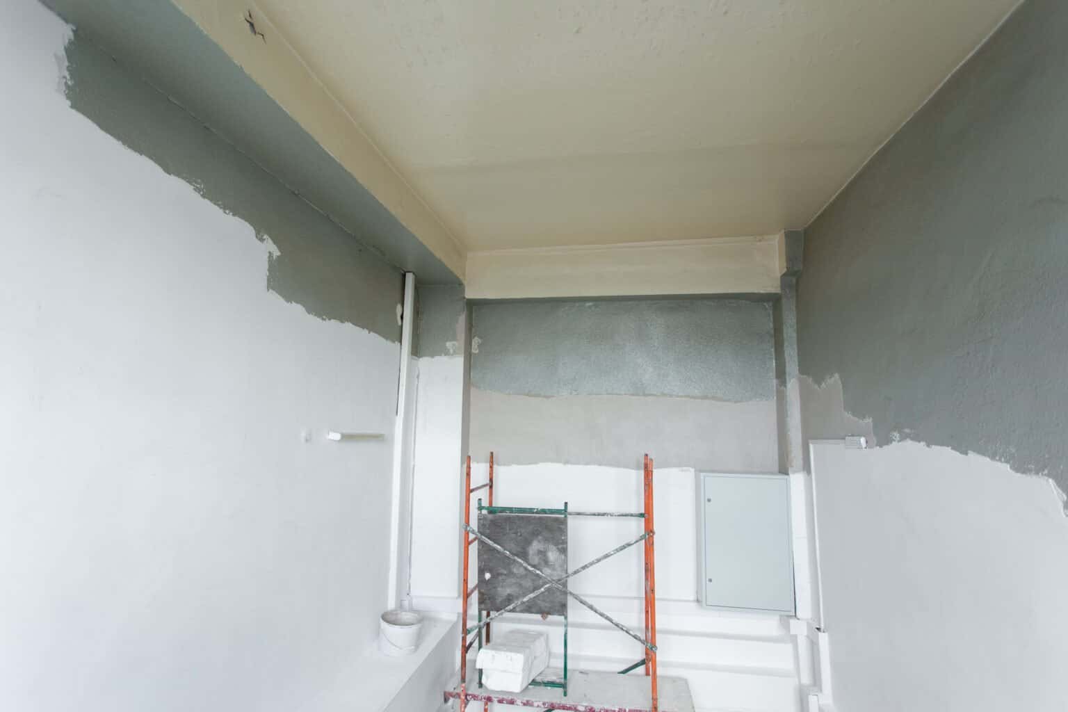 Interior wall painting with primer and fresh paint in a home renovation project.
