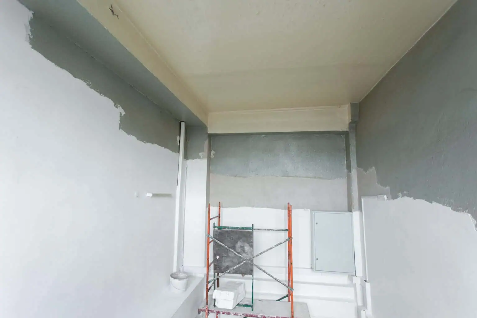 Interior wall painting with primer and fresh paint in a home renovation project.